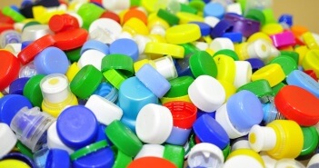Die Umwelt schützen: zwischen Besorgnis und Bestandswahrung Auf dem Foto liegen viele farbige Plastikdeckel auf einem Haufen.